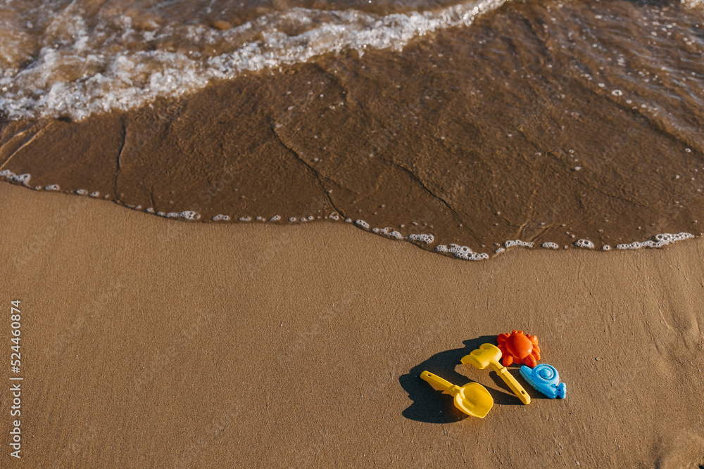 colorful sand child toys on seashore by the sea