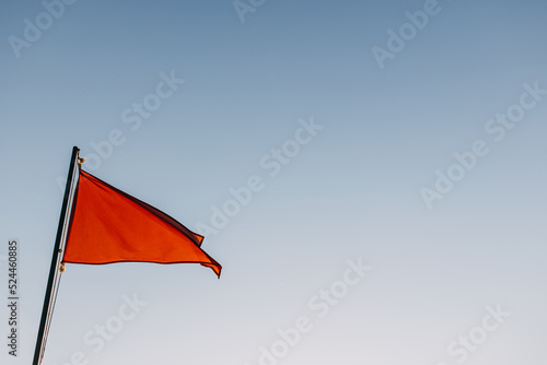 Fototapeta Naklejka Na Ścianę i Meble -  Red flag waving on a blue sky background.