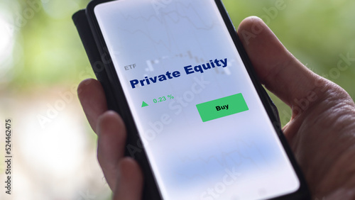 An investor's analyzing the private equity etf fund on screen. A phone shows the private equities ETF's prices momentum to invest.