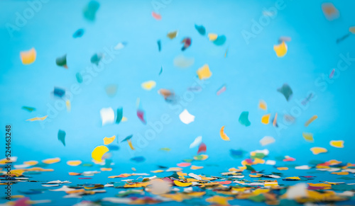 Colorful confetti in front of blue background © Bastian Weltjen
