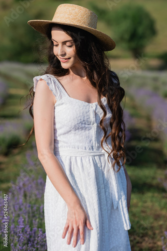 romantic woman in white dress in blurred summer field.