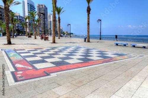 Corniche Beirut, in Lebanon, and the giant chess board painted on the floor. A paved street lined with palm trees perfect for a relaxing seaside promenade. 
