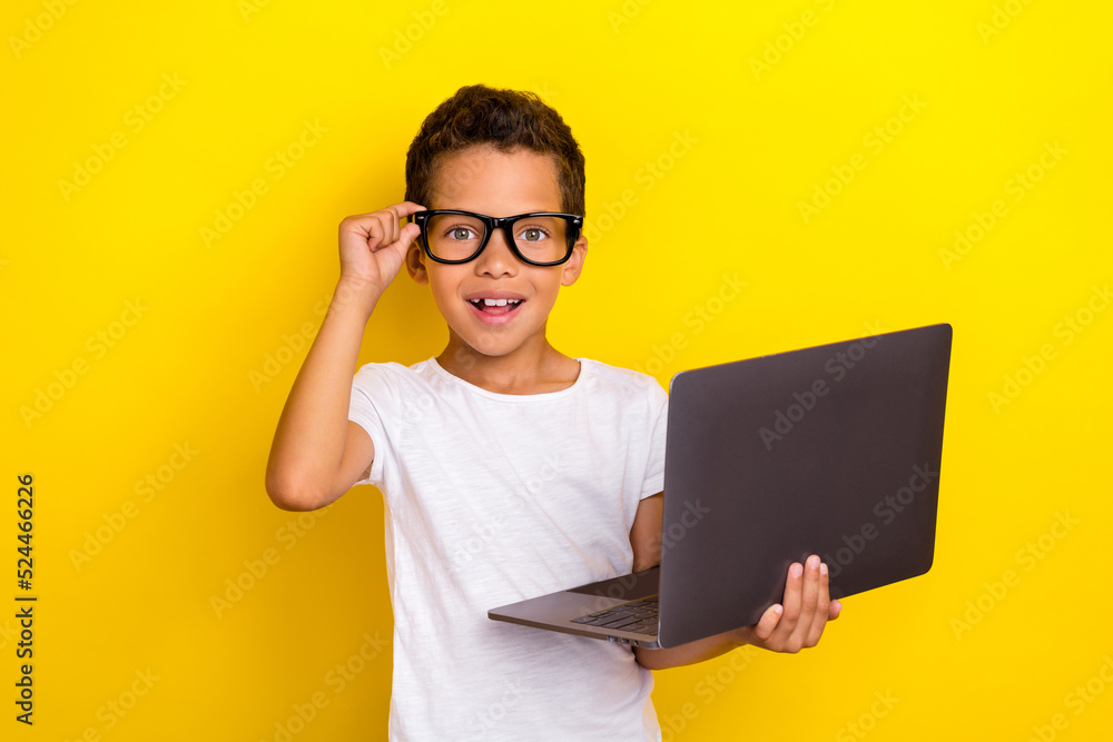 Photo of smart clever boy arm touch spectacles hold netbook enjoy online study lesson isolated on yellow background Photo of smart clever boy arm touch spectacles hold netbook enjoy online study lesson isolated on yellow background