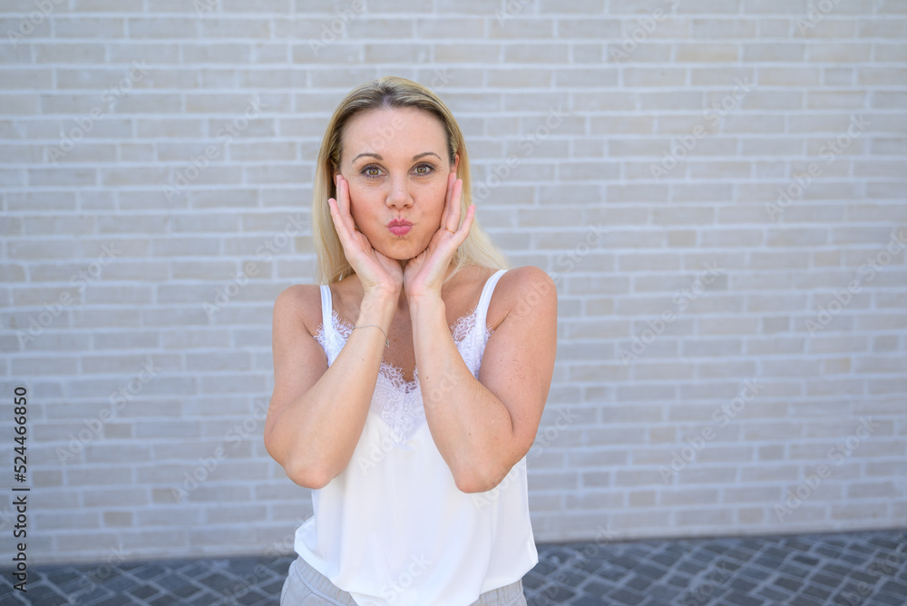 Simpering blond woman pursing her lips for the camera Simpering blond woman pursing her lips for the camera
