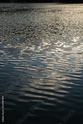 ฺBeautiful Reflected the sun rays hitting the water surface river is waves the sea surface before sunset natural background.