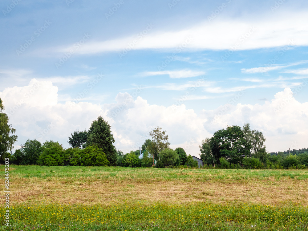 gray and white clouds in blue sky over mowed field after summer rain