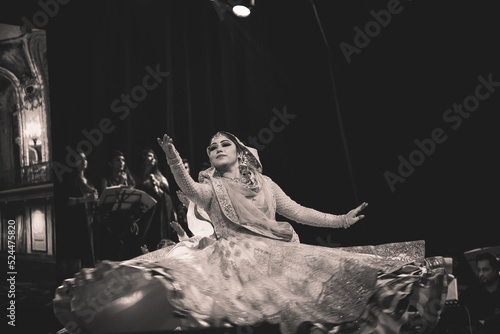 An elegant kathak dancer doing chakkar  in an rare artificial stage background photoshoot in black and white theme. photo