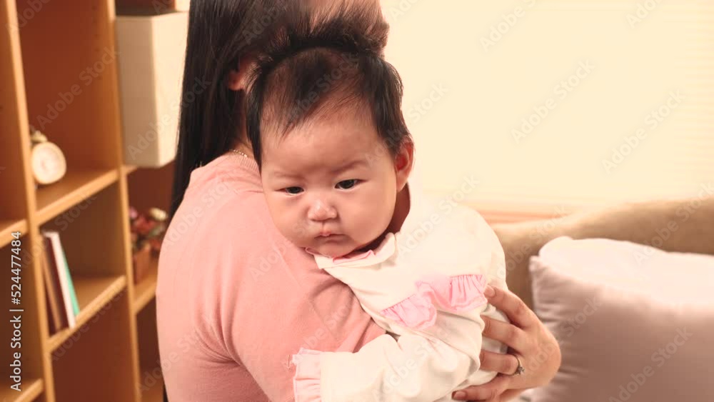 4K, Close Up is a 3-month-old newborn Asian girl who her mother is holding. A single mother is holding her newborn baby by soothing her to sleep. in the bedroom of the house. Family and Healthy. 4K, Close Up is a 3-month-old newborn Asian girl who her mother is holding. A single mother is holding her newborn baby by soothing her to sleep. in the bedroom of the house. Family and Healthy.