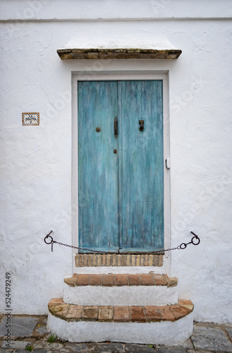 Blue turquoise wooden door at a typical white village house in Andalusia, south Spain