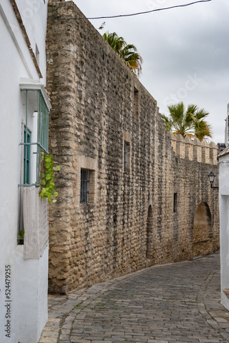 Alley in an ancient village of Vejer in Andalusia with medieval stone wall