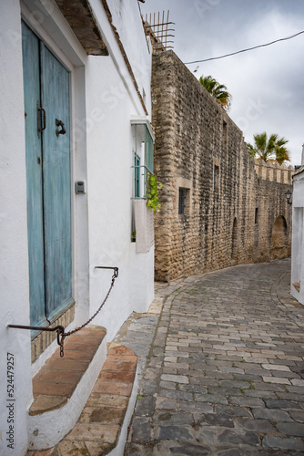 Alley in an ancient village of Vejer in Andalusia with medieval stone wall