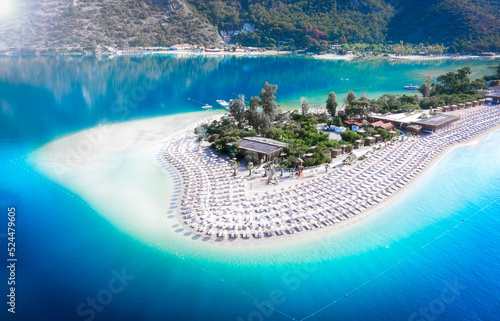Obraz na płótnie Summer landscape aerial view of turqurose lagoon with white sand and straw umbrallas. Top view of the bottom near the shore. Touristic place Oludeniz near Fethiye. w salonie