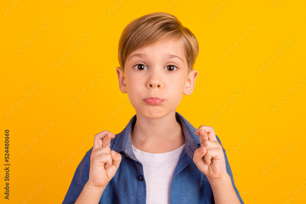 Photo of worried kid pouted lip crossed fingers expect hopeful isolated on yellow color background Photo of worried kid pouted lip crossed fingers expect hopeful isolated on yellow color background
