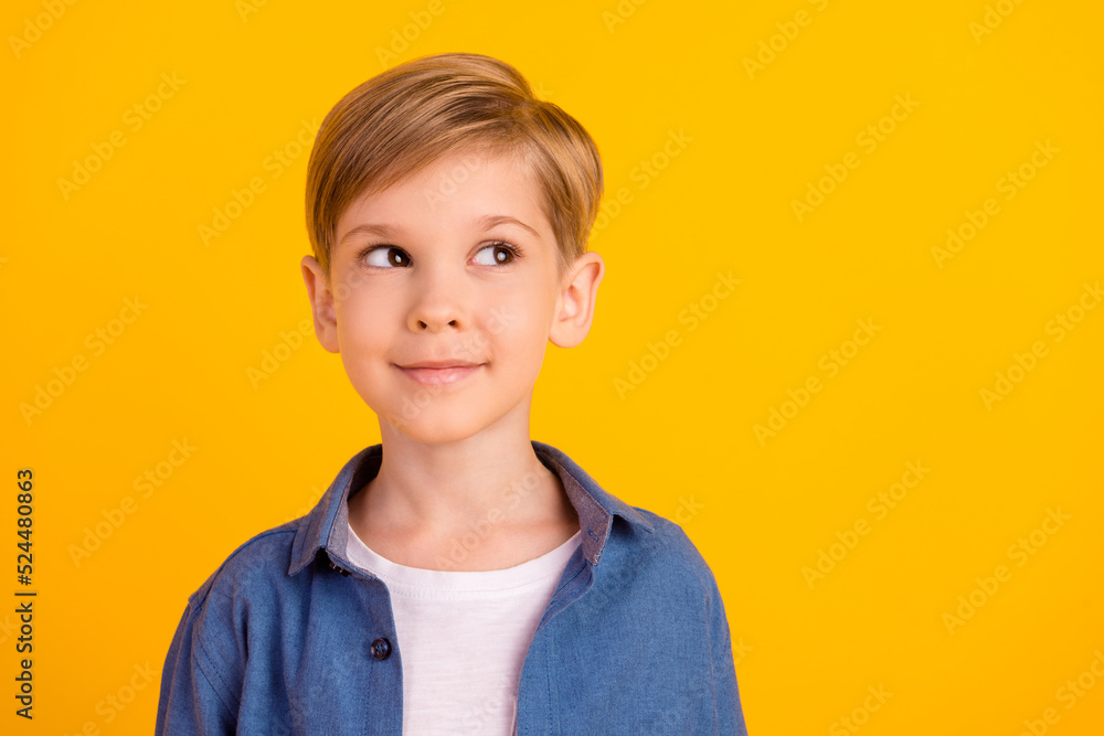 Photo of minded creative boy look interested empty space hmm deep isolated on yellow color background Photo of minded creative boy look interested empty space hmm deep isolated on yellow color background