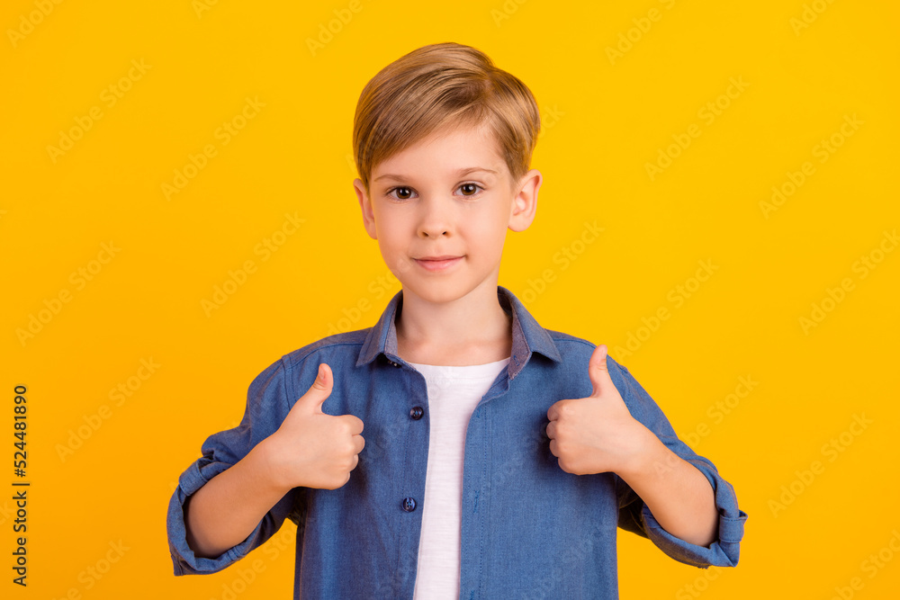 Photo of nice schoolboy hands fingers demonstrate thumb up feedback rate isolated on yellow color background Photo of nice schoolboy hands fingers demonstrate thumb up feedback rate isolated on yellow color background