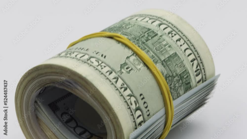 Bundle of money roll of dollars isolated on white background, stack of one hundred dollars American cash money bills rolled up with rubber band. Bundle of money roll of dollars isolated on white background, stack of one hundred dollars American cash money bills rolled up with rubber band.