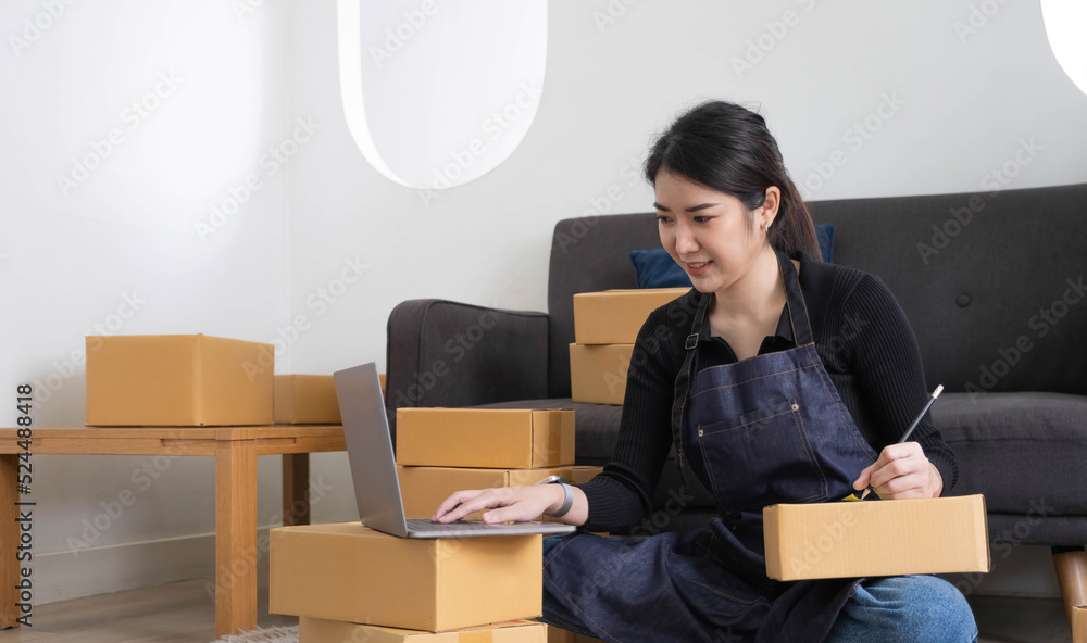 Portrait of Asian young woman SME working with a box at home the workplace.start-up small business owner, small business entrepreneur SME or freelance business online and delivery concept. Portrait of Asian young woman SME working with a box at home the workplace.start-up small business owner, small business entrepreneur SME or freelance business online and delivery concept.