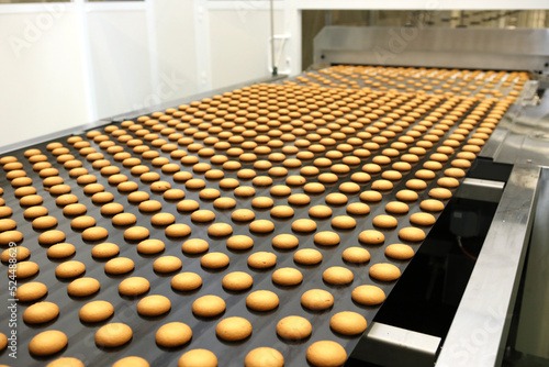 Controlling the work of huge conveyor machine producing spice cakes at the confectionary plant. Cookie production line. Innovative biscuit production. © neznamov1984