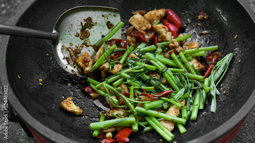 Stir-Fried Chinese Morning Glory with chicken in frying pan background.traditional food asian Thailand.Hot and spicy. Food for good health and diet.