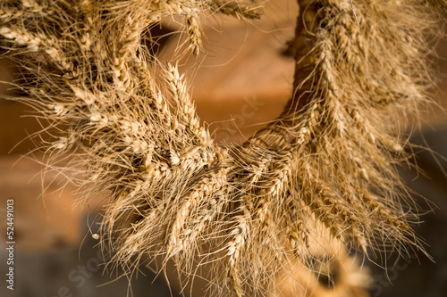 Close-up of wreath of spikelets. Boho style. Ripe wheat. Harvest.