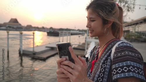 Asian Female Tourist is taking selfie in Chaopraya river in Bangkok, Thailand.
