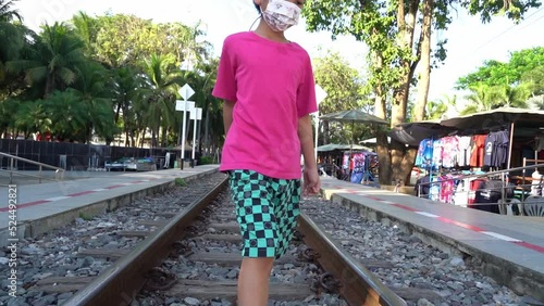Asian kids in walking on a Train tack in Kanchanaburi, Thailand.