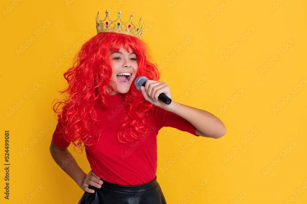 smiling child in crown with microphone on yellow background smiling child in crown with microphone on yellow background