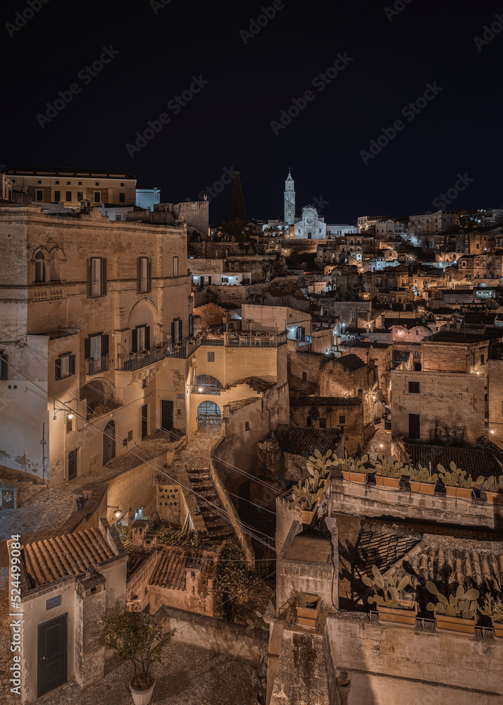 Matera by night, photos from the panoramic terrace. Photo from June 2022. You can see the basilica overlooking the town and the characteristic houses carved into the rock. Matera was the European capi