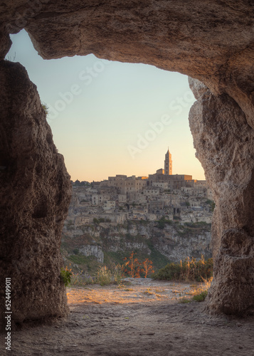 Matera at Sunset, photo from a grotto that frames it. Photo from June 2022. You can see the basilica overlooking the town and the characteristic houses carved into the rock. Matera was the European ca
