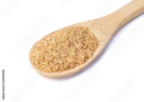 Raw brown whole rice in a spoon isolated over white background