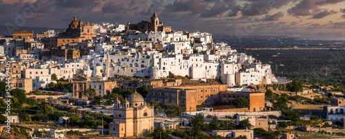 Overview of Ostuni (BR), the white city perched on the hill, with the typical white houses. Aerial photo with the drone of June 2022 photo taken at dawn.