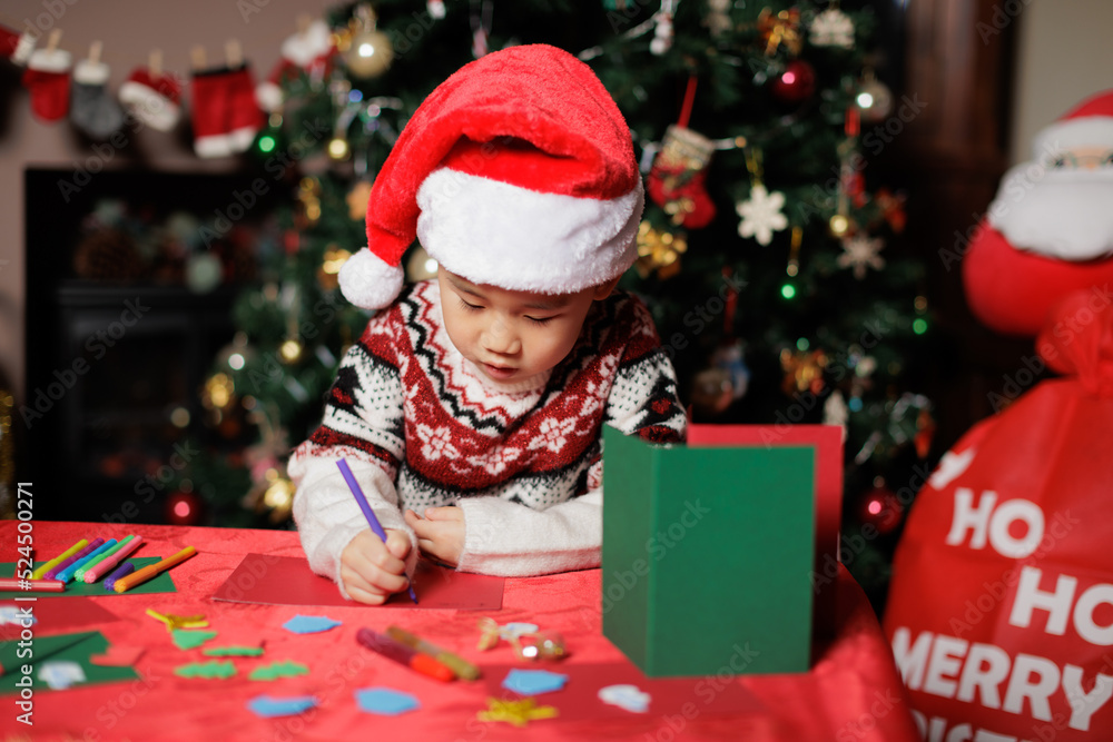 medium shot young girl making Christmas card in front of Christmas tree medium shot young girl making Christmas card in front of Christmas tree