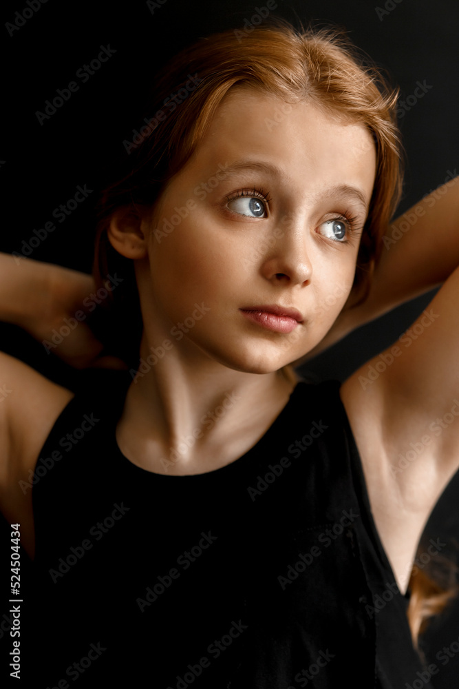 Close-up portrait of a adorable little girl with long red hair on black studio background. Fashion kids model Close-up portrait of a adorable little girl with long red hair on black studio background. Fashion kids model