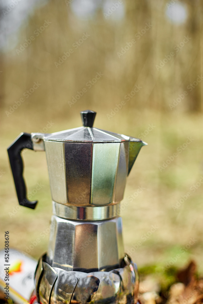 Making camping coffee from a geyser coffee maker on a gas burner