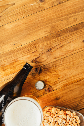 Bottle beer with snacks on wood table.