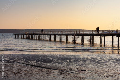 High quality photo of a pier at sundown. Wooded bridge seaside with Sunset  Strunjan. Slovenia