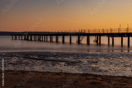 High quality photo of a pier at sundown. Wooded bridge seaside with Sunset, Strunjan. Slovenia