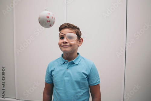 A child undergoes vision therapy in an optician. Marsden ball. photo