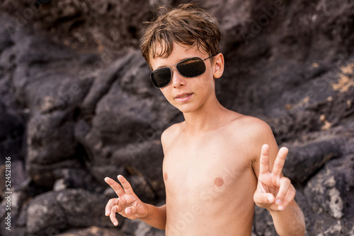Photography funny portrait of young shirtless man wearing sunglasses in an exotic beach