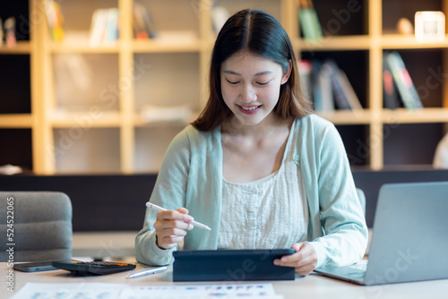 Young Business Asian woman sitting at a desk with a laptop and working in the home office or her workplace, accountant tax contract report analysis document data Audit concept.