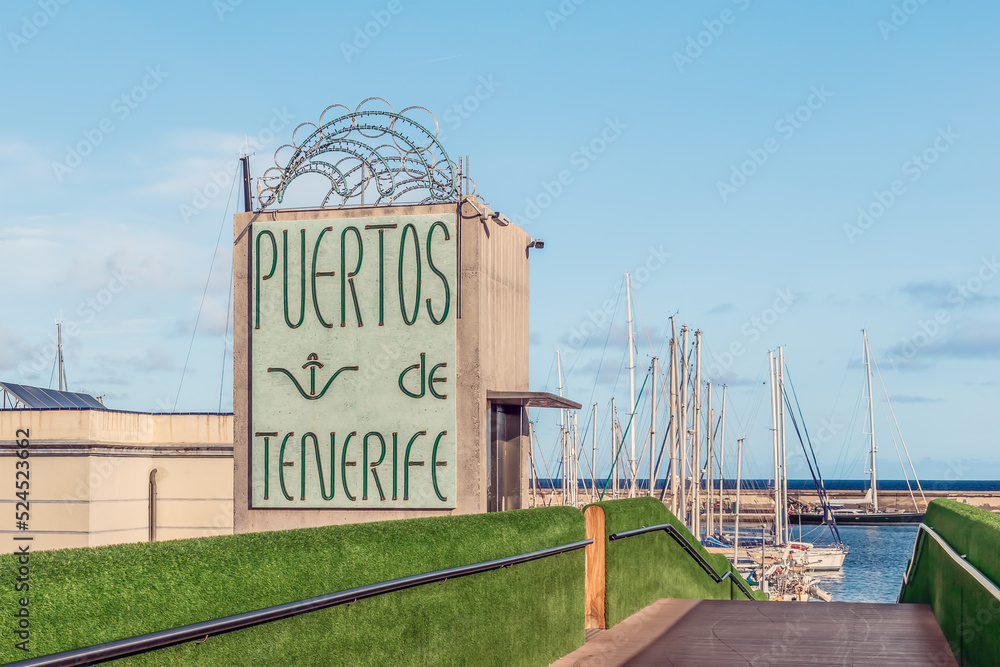 Fototapeta premium Santa Cruz de Tenerife, Spain - November 24, 2021: Sign with text Puertos de Tenerife on the coast of the Atlantic Ocean in Santa Cruz de Tenerife. Signboard of the Port of Santa Cruz de Tenerife