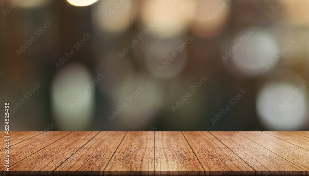 Empty wooden table top with lights bokeh on blur restaurant background.