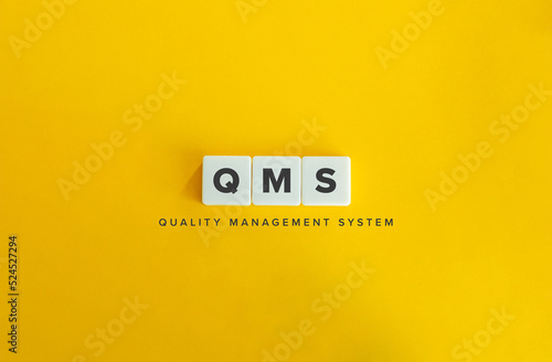 Quality Management System (QMS) Banner. Block Letter Tiles on Yellow Background. Minimal Aesthetics. photo