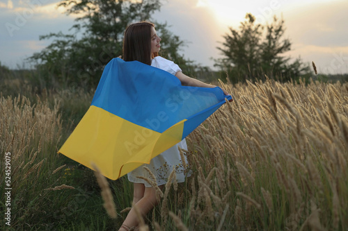 girl runs to the sun with the flag of Ukraine. High quality photo