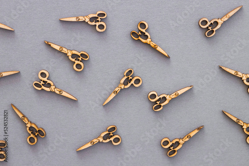 Wooden figures in the form of scissors on a grey background