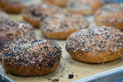 Close-up of freshly baked bagels with seeds on top. Intentional selective focus with shallow depth of field.