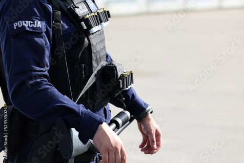 Policjant oddziału prewencji na zabezpieczeniu imprezy sportowej. Tarcza policyjna. 
