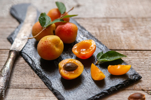 Ripe juicy apricots in a white bowl on a wooden background