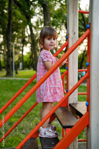 Cute baby girl Playing At Playground In Summer Sunny Day. Little girl licking chupa chups © tygrys74