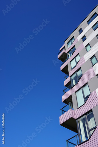 Abstract and close up of lilac, grey color building facade on a sunny day towards clear blue clear sky. Tallinn, Estonia, Europe. August 2022